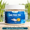 Bột Cam Phục Tra SH Group 100g đặt chính diện trên bệ đá cạnh hồ, nhãn sản phẩm SH Group hiển thị rõ.