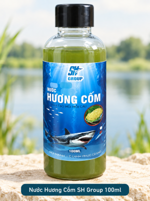 Một chai Nước Hương Cốm SH Group 100ml đặt trên bệ đá bên hồ nước ngọt, nhãn sản phẩm SH Group hướng chính diện.